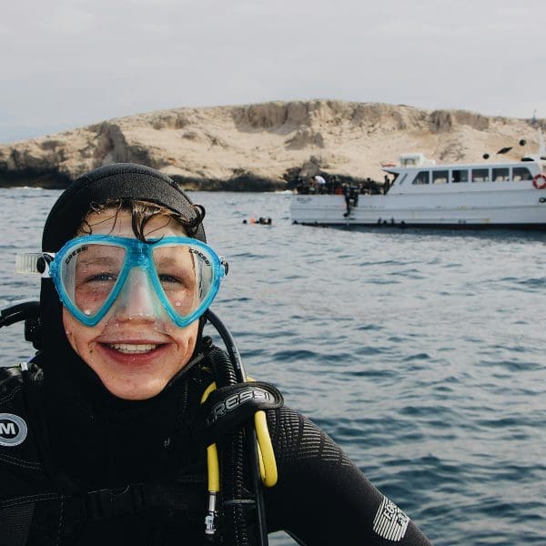 Beginner scuba diver learning underwater skills in a training pool.