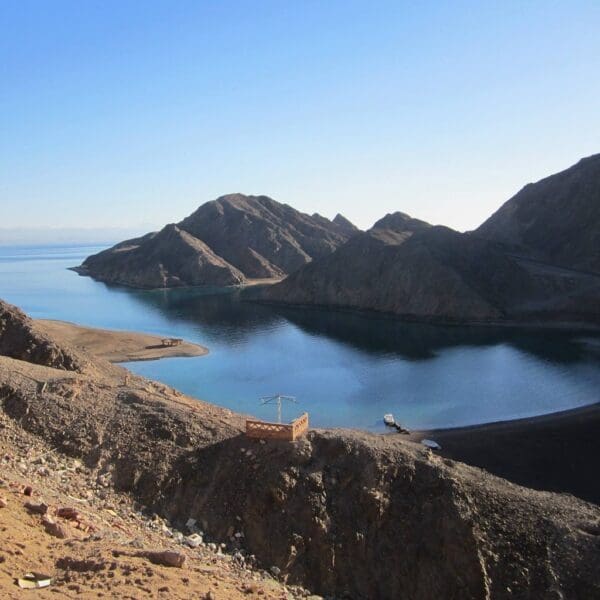 Serene mountainous coastline with calm blue water.
