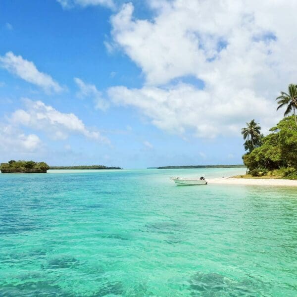 Tropical beach with clear turquoise water and boat.