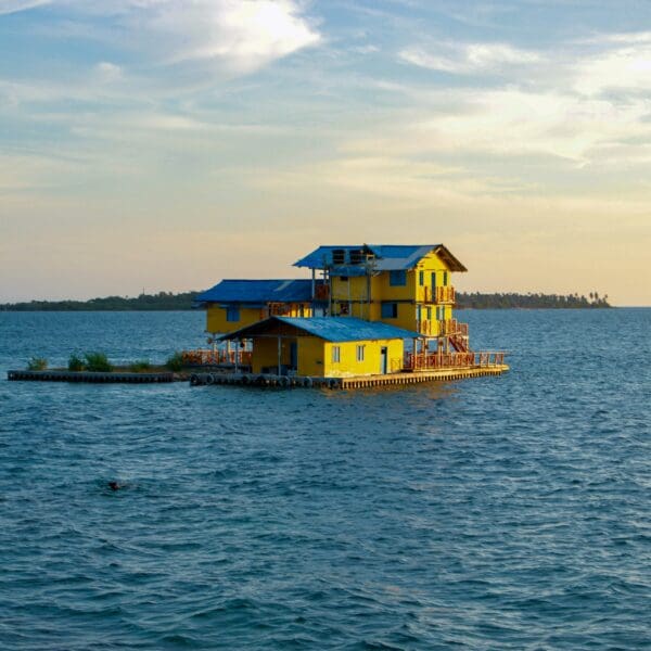 Yellow floating house on serene blue ocean
