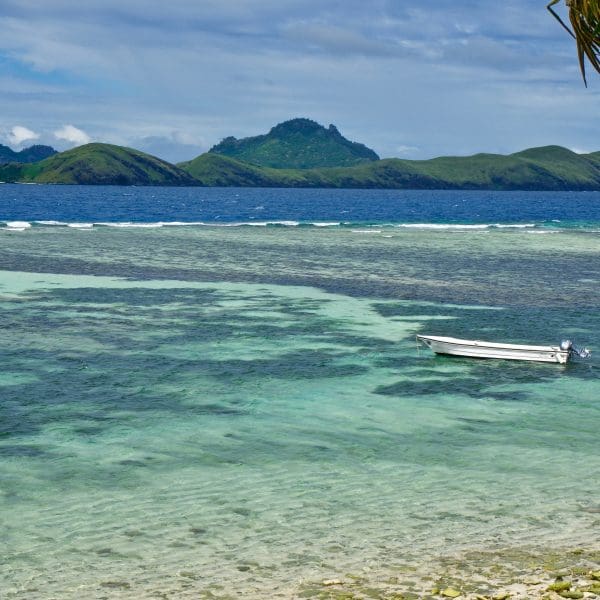 Tropical lagoon with boat and distant island hills.