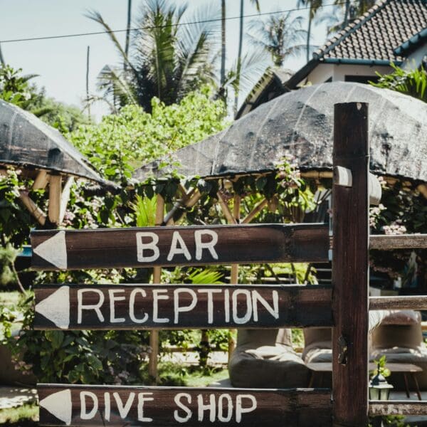 Wooden signpost with directions to bar, reception, dive shop.