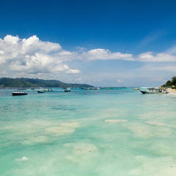 Tropical beach with boats and clear turquoise water