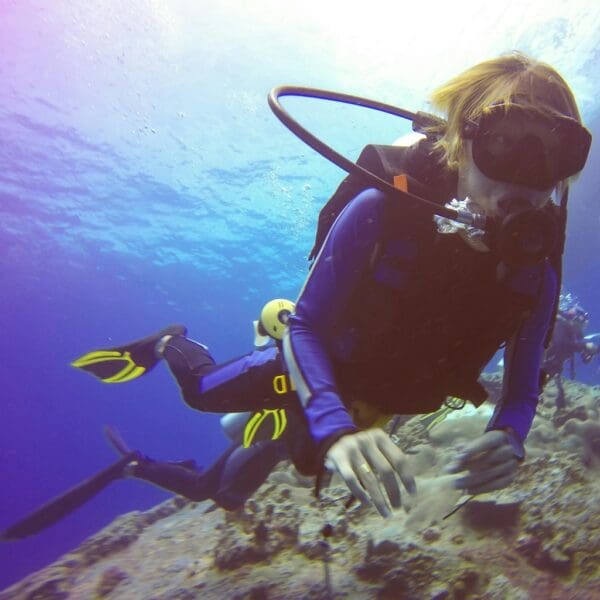Scuba diver exploring under clear blue ocean waters.