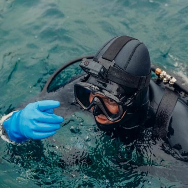 Scuba diver with camera on helmet in ocean.