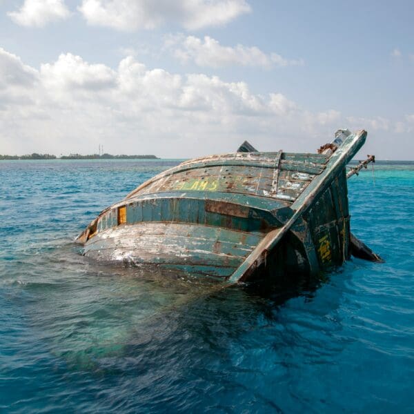 Sunken boat in clear turquoise ocean water