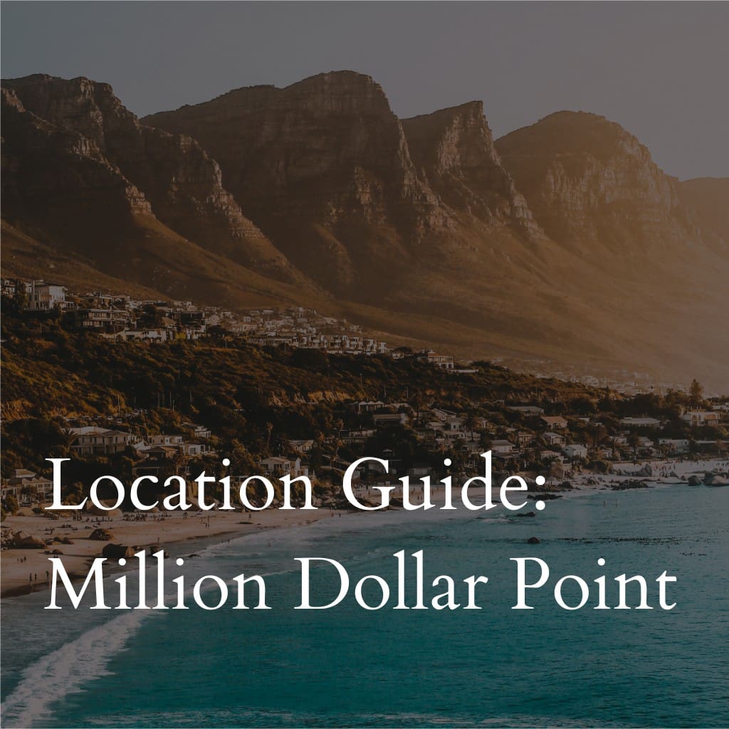 Seaside town with mountains at sunset, titled Million Dollar Point