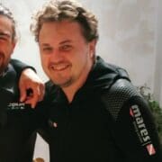 Two men smiling in black diving suits