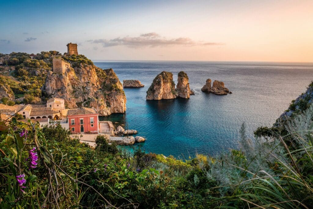 Coastal village, rocky cliffs, ancient tower, sunset view