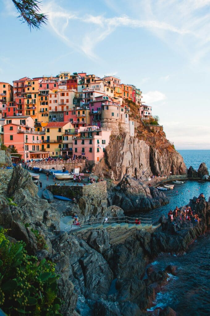 Colorful buildings on cliff overlooking sea at sunset