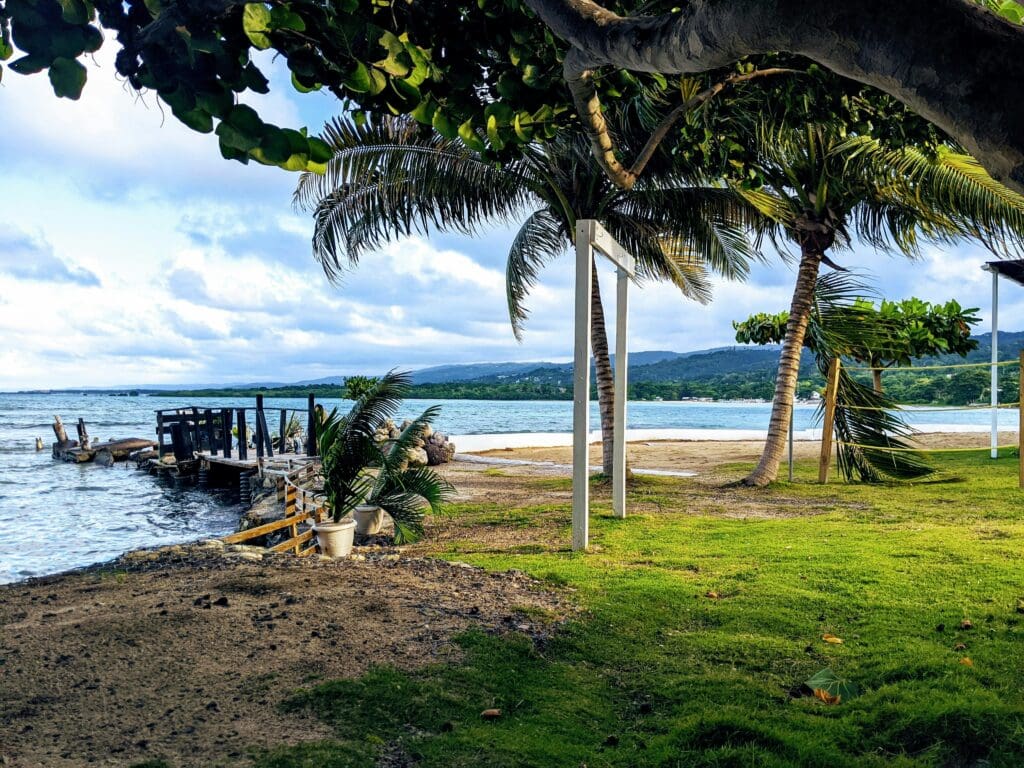 Tropical beach landscape with wooden pier and palm trees