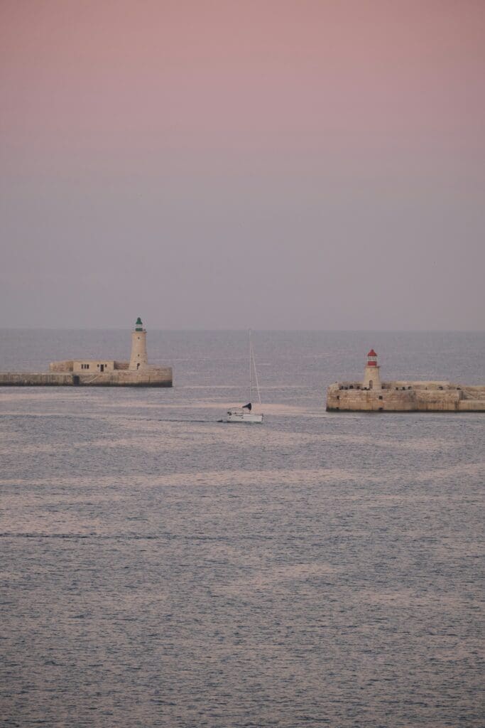 Sailboat between two lighthouses at dusk