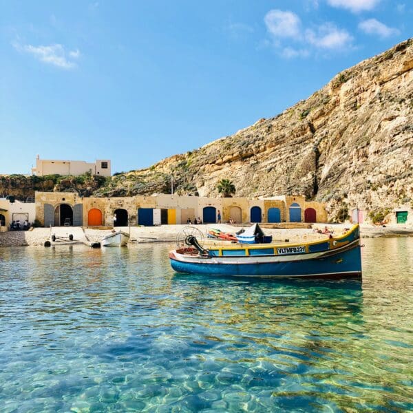Colorful boats by rocky cove with clear blue water
