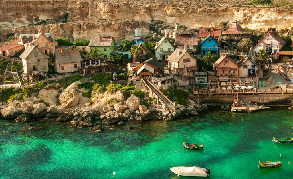 Colorful coastal village with cliffs and clear turquoise sea