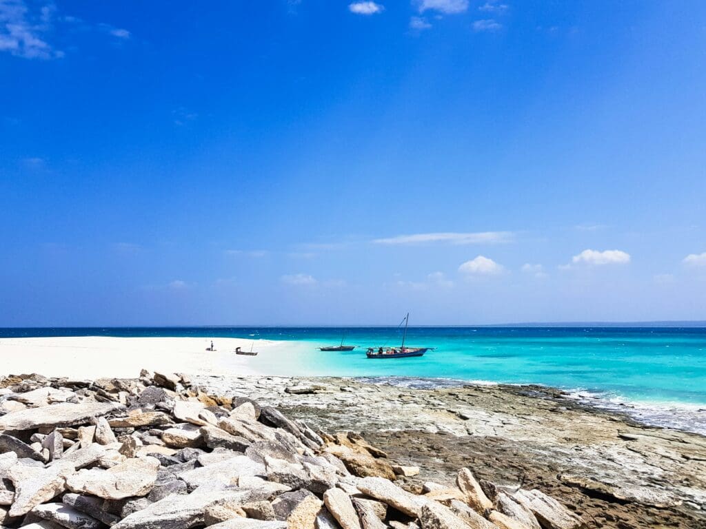 Tropical beach with clear blue water and boats