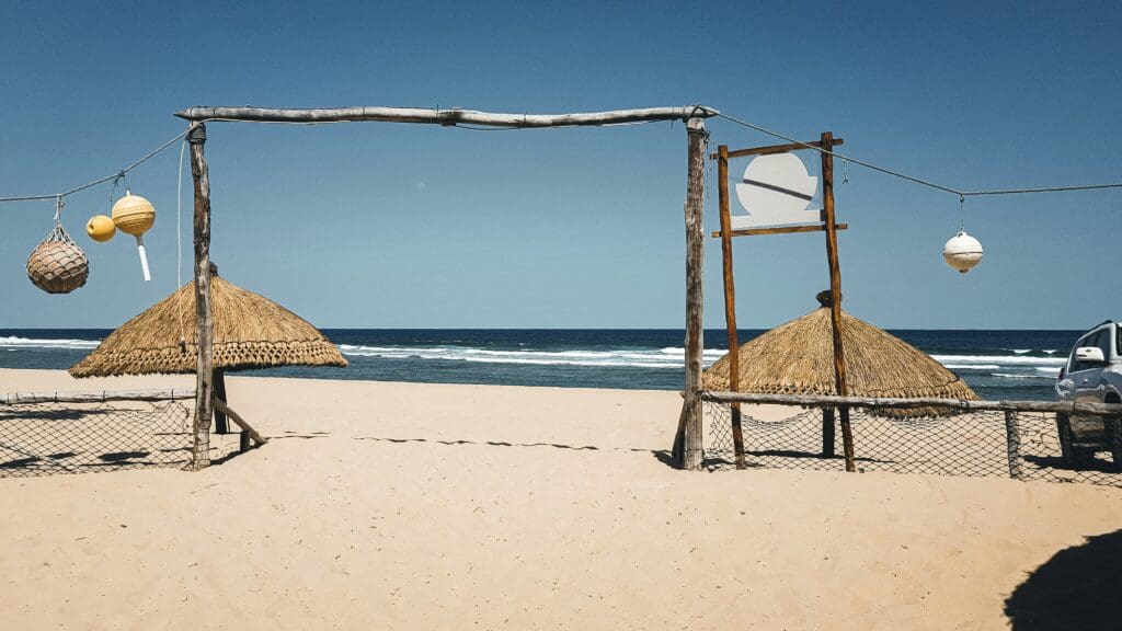 Beachfront huts with hanging lanterns on sunny day