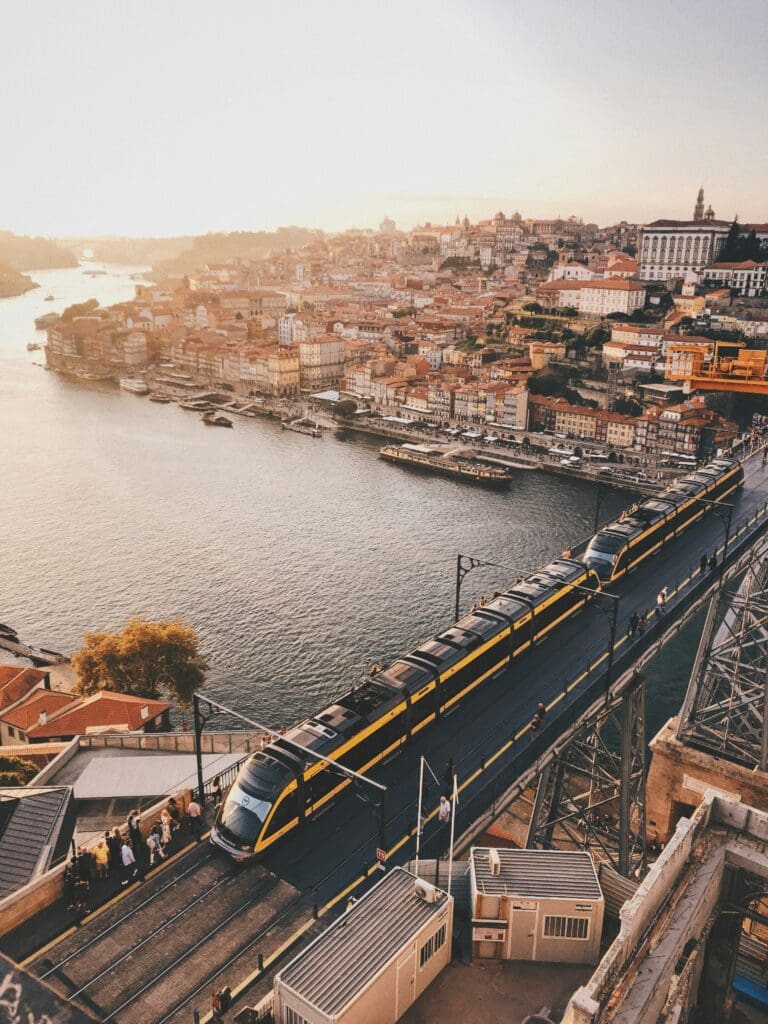 Sunset view of train, river, and cityscape