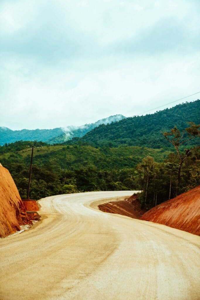Curvy dirt road through misty mountainous landscape