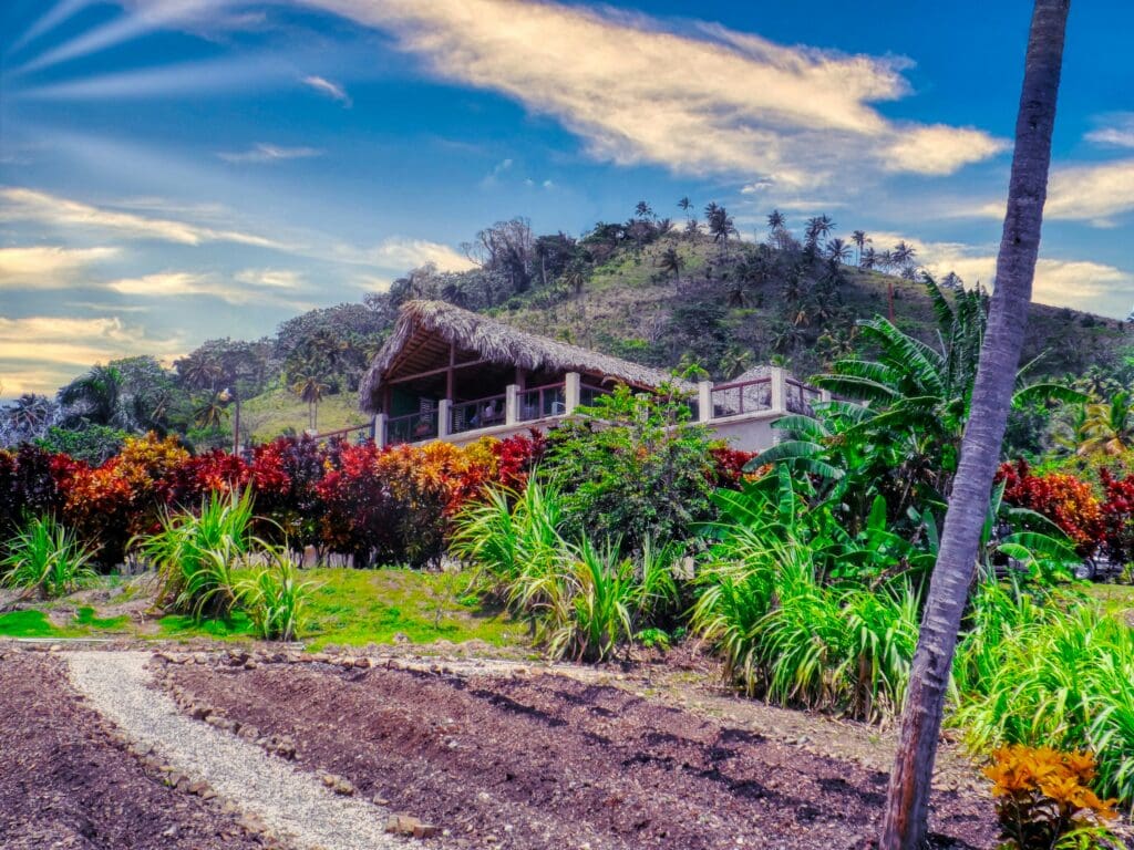 Tropical hillside home surrounded by lush colorful garden