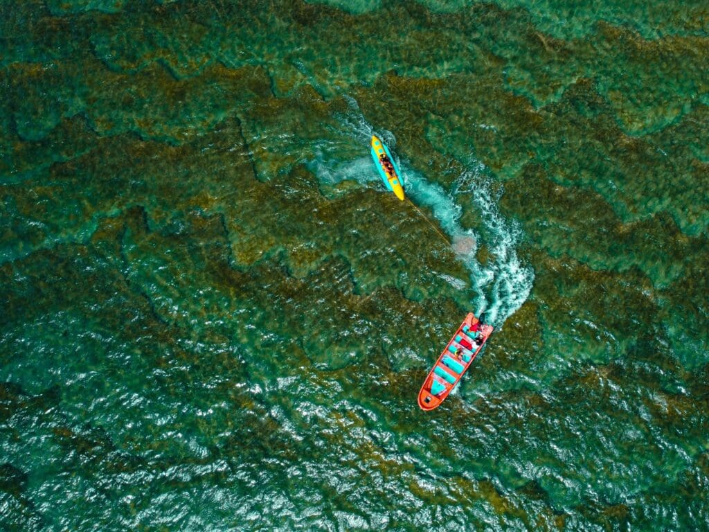 Aerial view of two kayaks racing on turquoise water