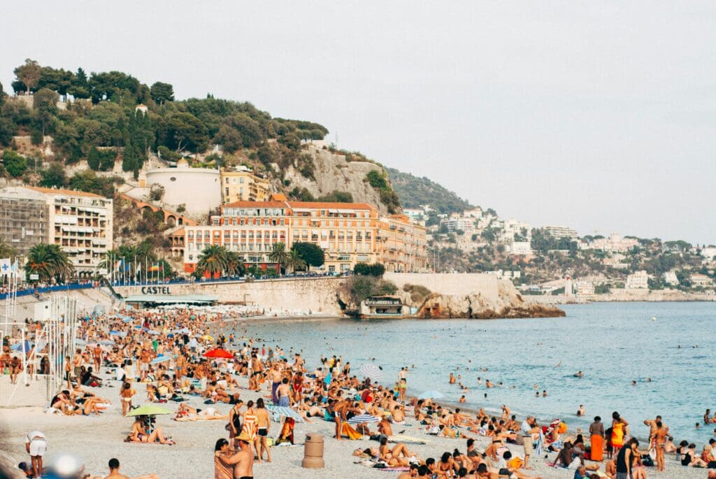 Crowded beachfront with cityscape and cliffside view