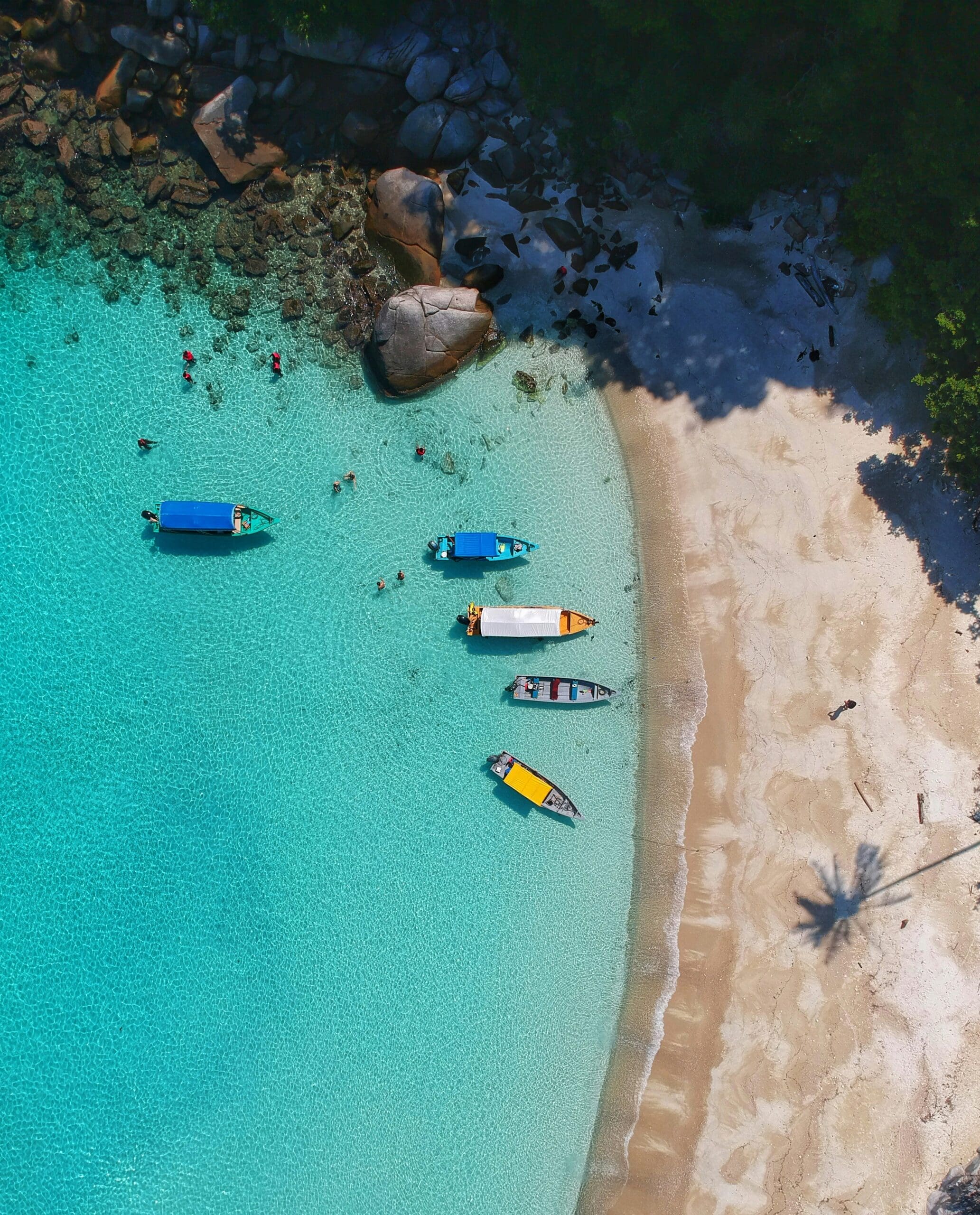 Aerial view of boats on turquoise water near beach