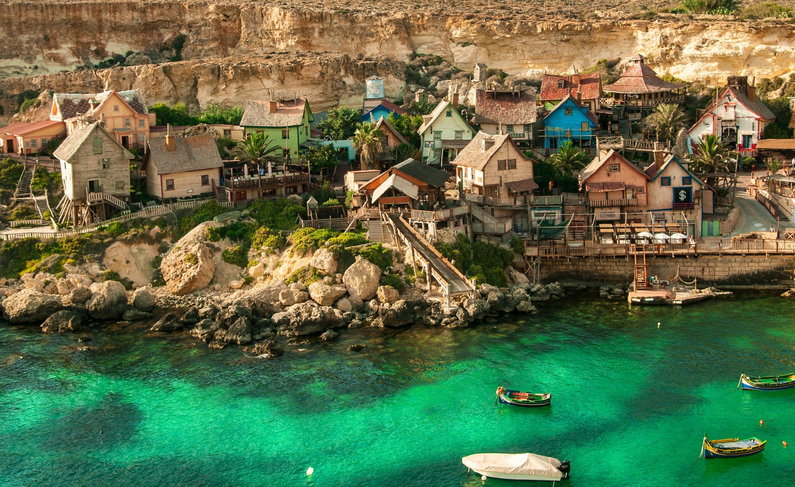 Colorful coastal village with wooden houses and turquoise sea