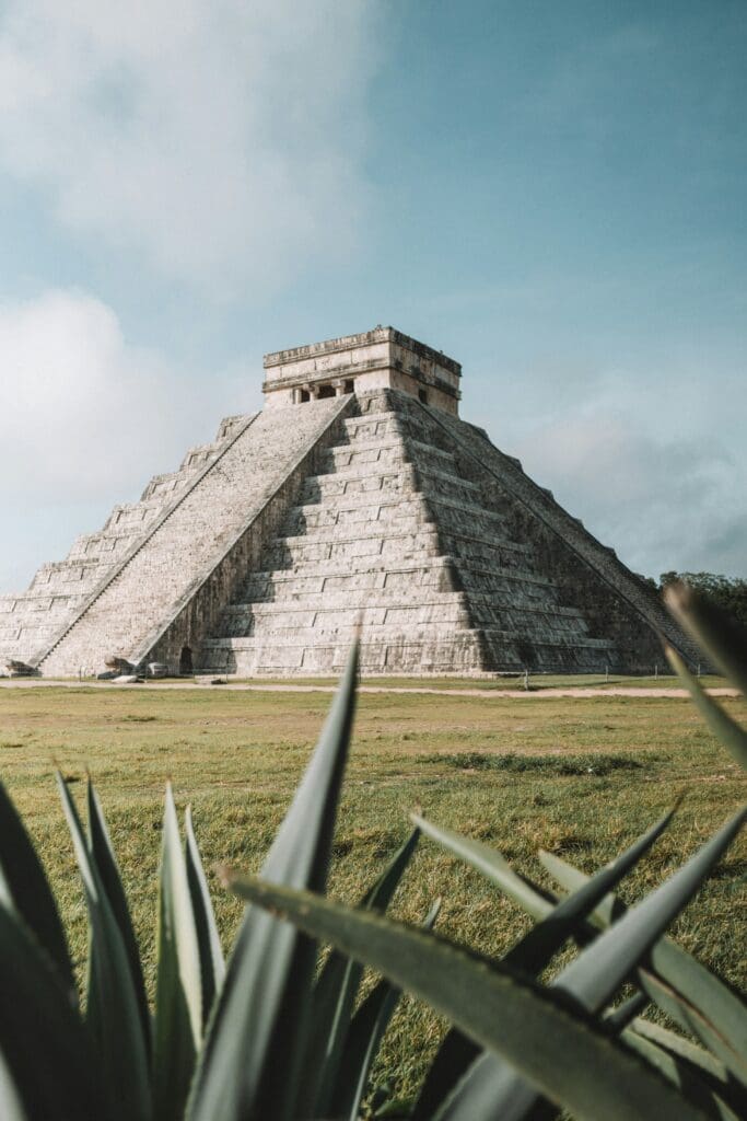 Ancient Mayan pyramid at Chichen Itza with foreground foliage