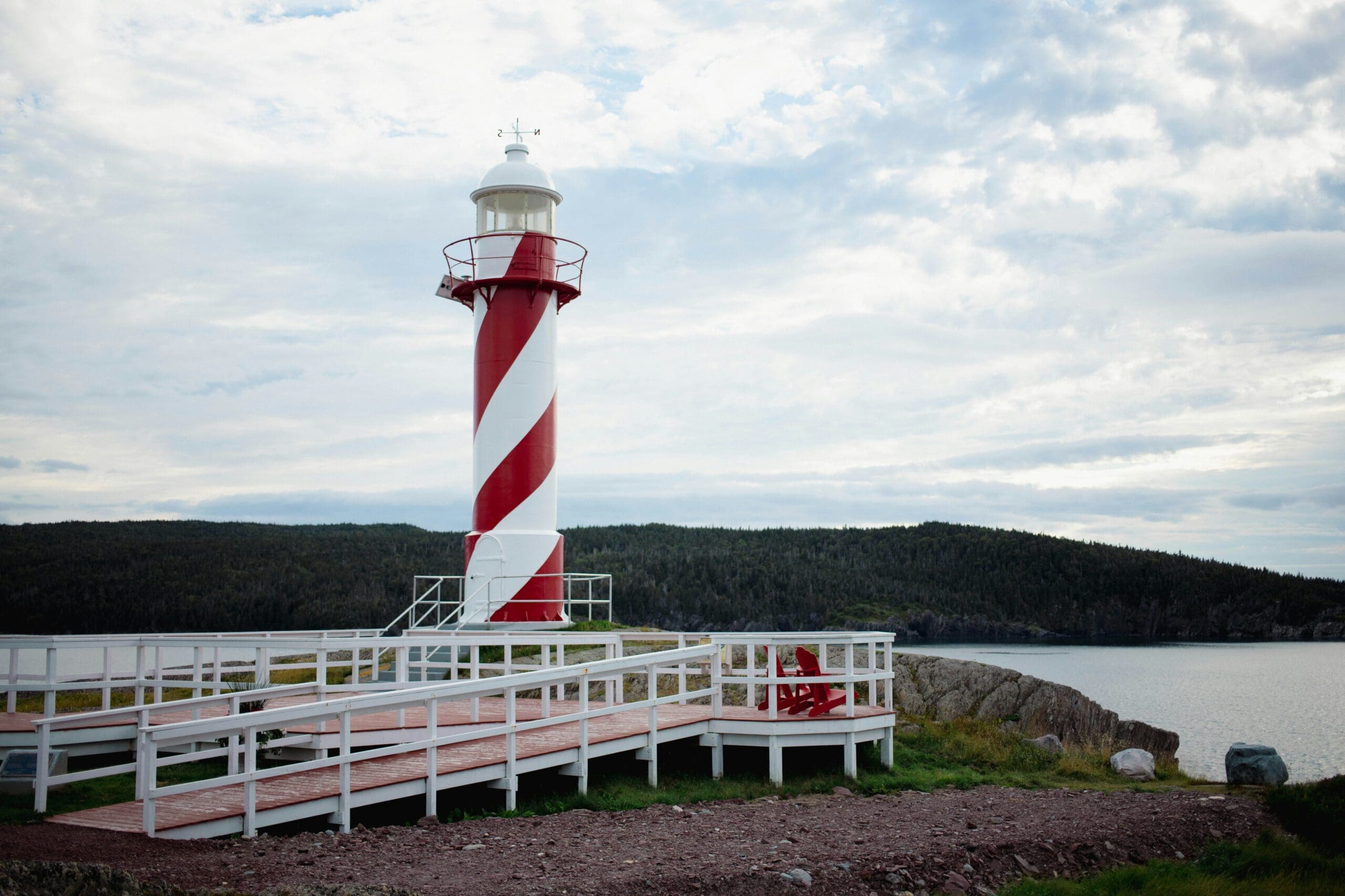 Red and white striped lighthouse by the sea