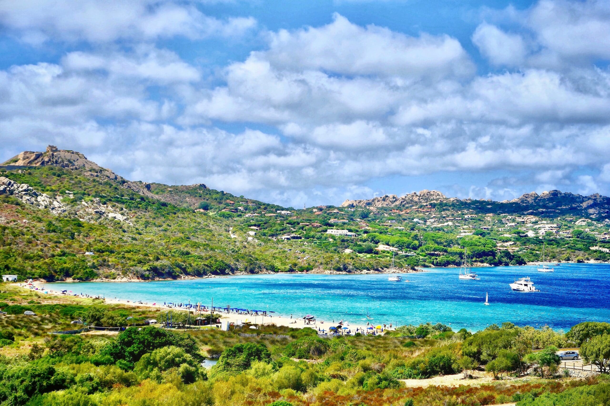 Scenic view of beach with lush hills and blue water