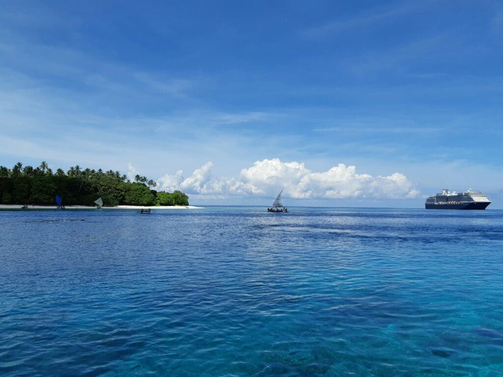 Cruise ship near tropical island with clear blue ocean