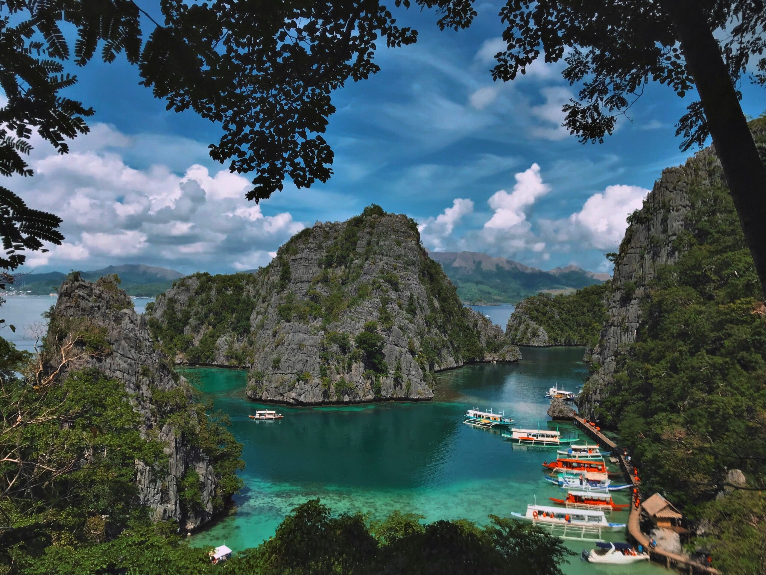 Turquoise bay surrounded by rugged cliffs and boats