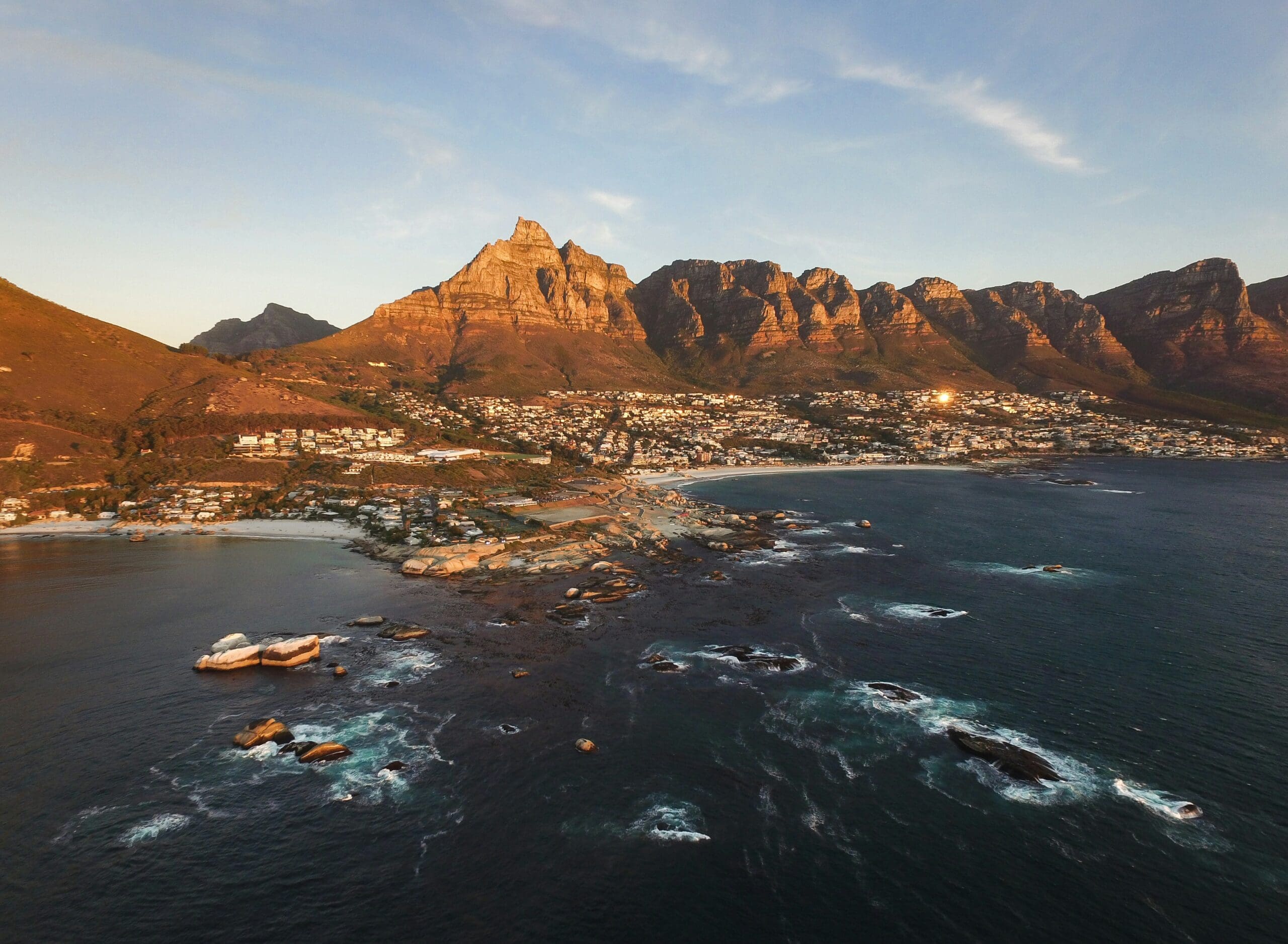 Aerial view of coastal town with mountain backdrop