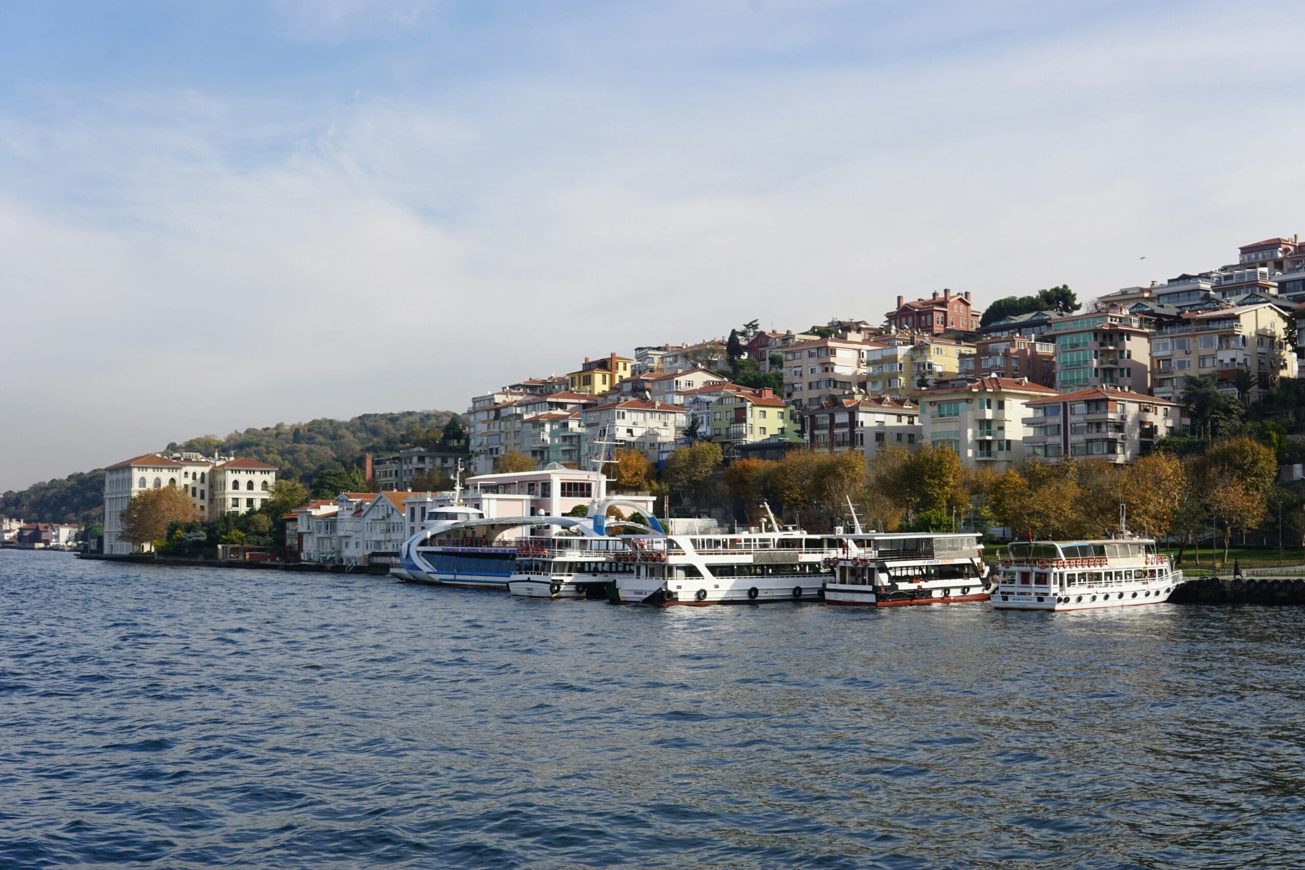 Scenic waterfront with boats and colorful hillside buildings