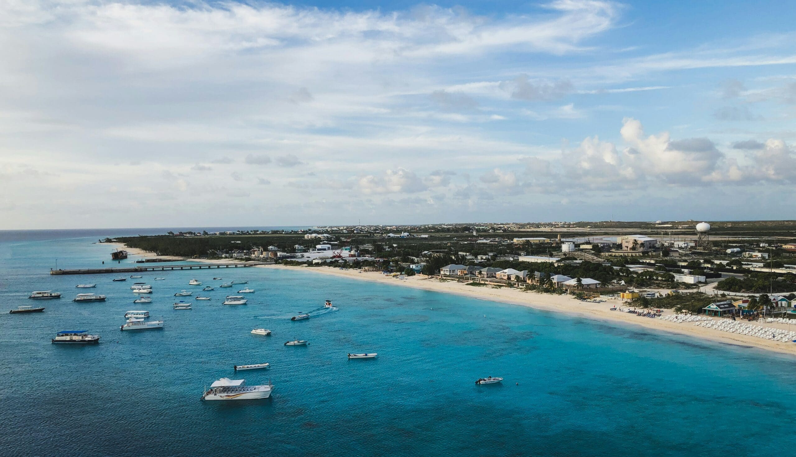 Aerial view of coastal town with boats and turquoise water