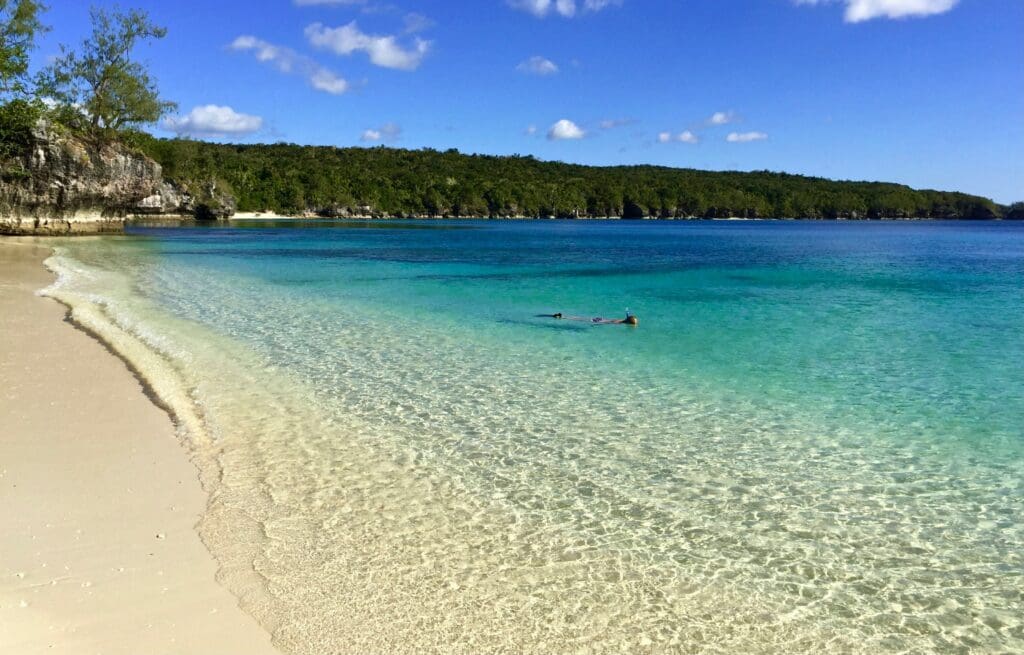 People snorkeling in clear turquoise tropical beach