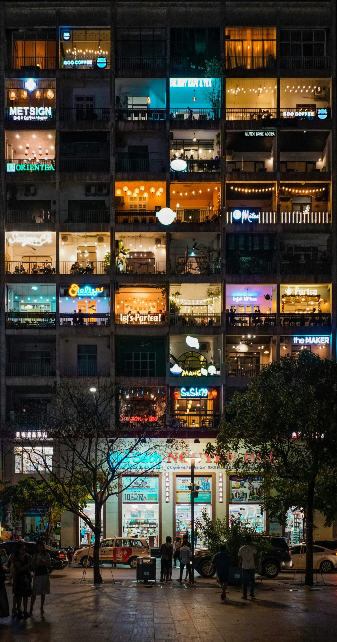 Vibrant multi-story building with illuminated shops at night