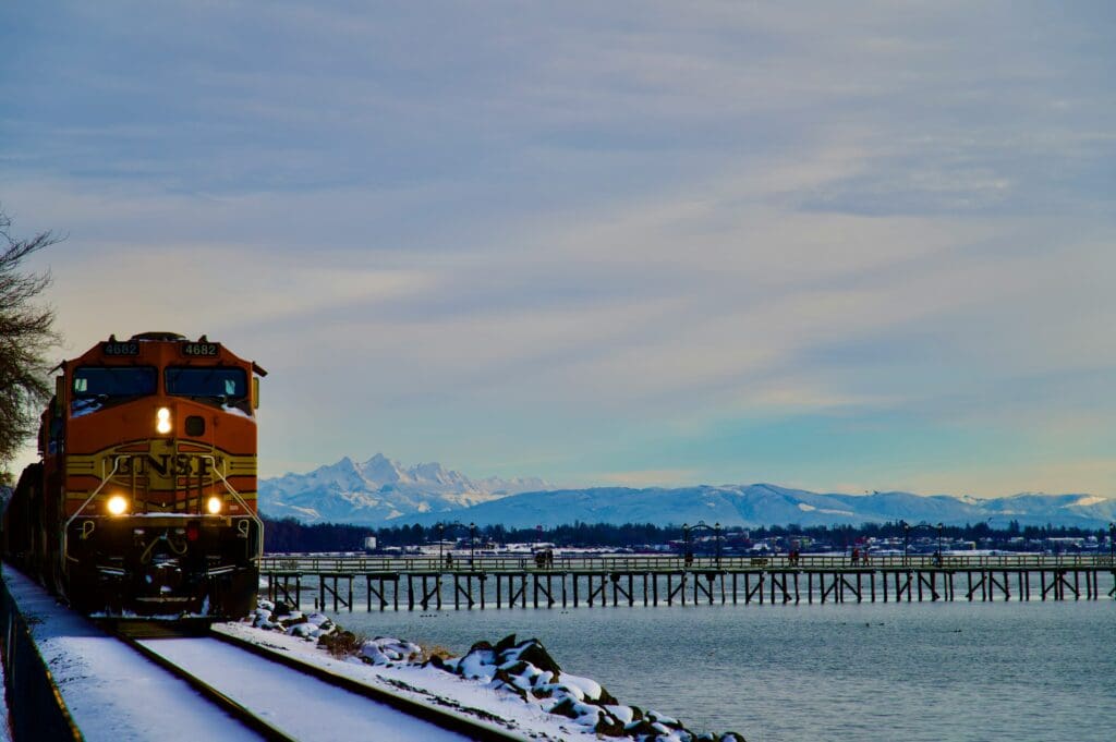 Train on snowy track with distant mountains